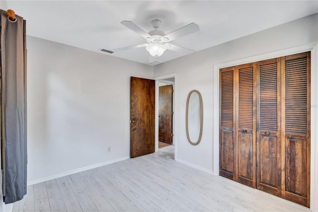 6443 34th Ave N, Saint Petersburg, FL 33710 - unfurnished bedroom featuring a closet, light wood-style floors, baseboards, and a ceiling fan