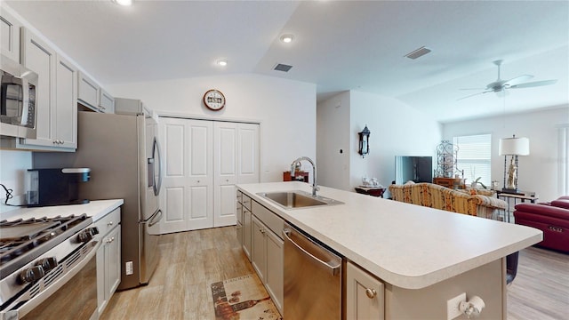3817 Miragalia Ln, The Villages, FL 32163 - kitchen featuring appliances with stainless steel finishes, lofted ceiling, a sink, light wood-type flooring, and light countertops