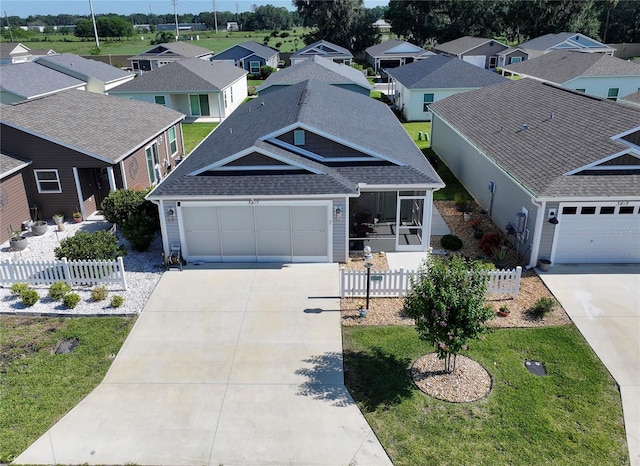 3817 Miragalia Ln, The Villages, FL 32163 - view of front facade featuring a shingled roof, concrete driveway, a residential view, and a garage