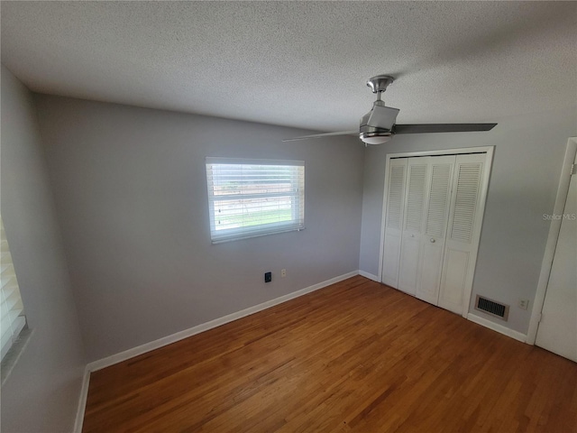 6924 Nawadaha Blvd, Orlando, FL 32818 - unfurnished bedroom with wood finished floors, a textured ceiling, a closet, and a ceiling fan