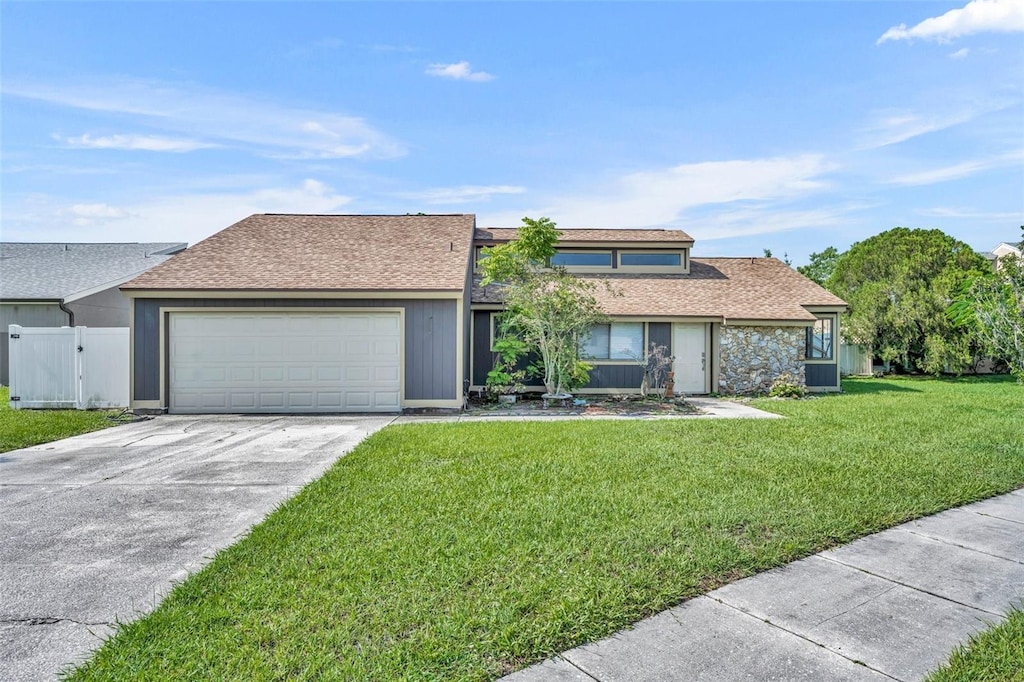 2104 Winding Ridge Ave S, Kissimmee, FL 34741 - mid-century home featuring roof with shingles, an attached garage, driveway, and a gate