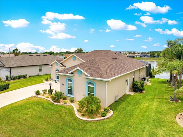 11215 SE 172nd Pl, Summerfield, FL 34491 - mediterranean / spanish house with stucco siding, driveway, a front lawn, a shingled roof, and a water view