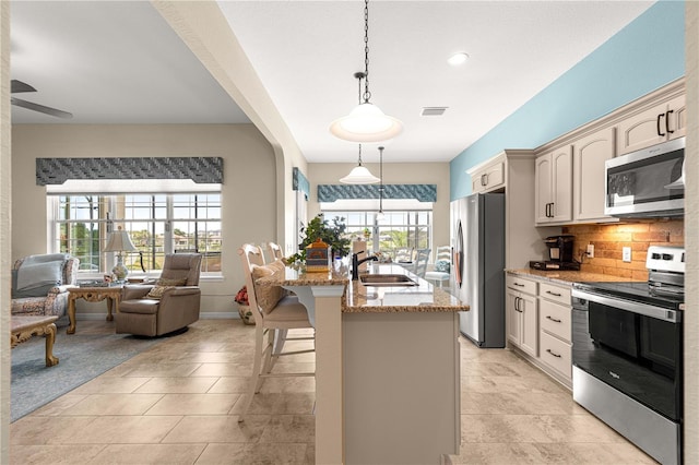 11215 SE 172nd Pl, Summerfield, FL 34491 - kitchen featuring stainless steel appliances, light stone counters, a breakfast bar area, hanging light fixtures, and open floor plan
