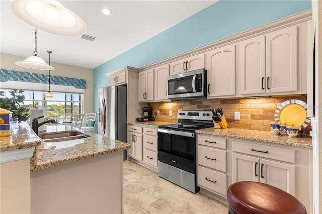 11215 SE 172nd Pl, Summerfield, FL 34491 - kitchen with appliances with stainless steel finishes, decorative backsplash, decorative light fixtures, light stone counters, and cream cabinets
