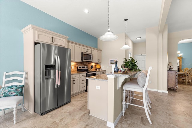 11215 SE 172nd Pl, Summerfield, FL 34491 - kitchen with appliances with stainless steel finishes, arched walkways, decorative backsplash, a center island, and a breakfast bar area
