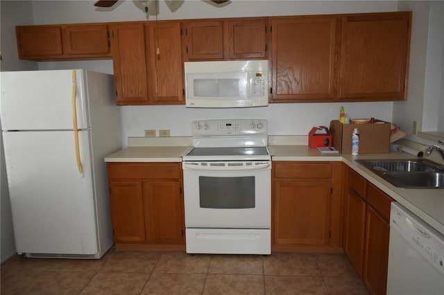 610 Swallow Ct, Apopka, FL 32712 - kitchen with white appliances, a sink, light countertops, brown cabinetry, and light tile patterned floors
