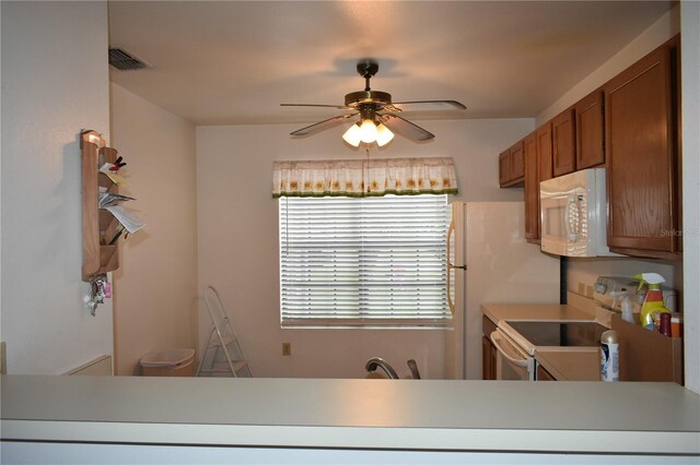 610 Swallow Ct, Apopka, FL 32712 - kitchen with white appliances, brown cabinetry, ceiling fan, and light countertops
