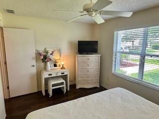 3337 Candlebrook St, The Villages, FL 32162 - bedroom featuring multiple windows, a textured ceiling, dark wood-style flooring, and a ceiling fan