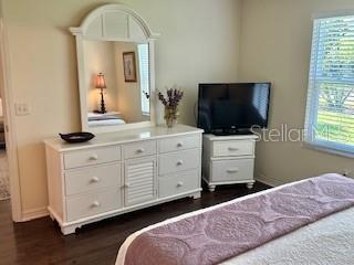 3337 Candlebrook St, The Villages, FL 32162 - bedroom with multiple windows, dark wood finished floors, and baseboards