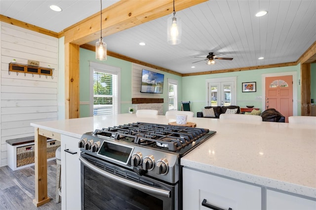 378 W Osceola St, Clermont, FL 34711 - kitchen with stainless steel gas range oven, open floor plan, white cabinetry, recessed lighting, and crown molding