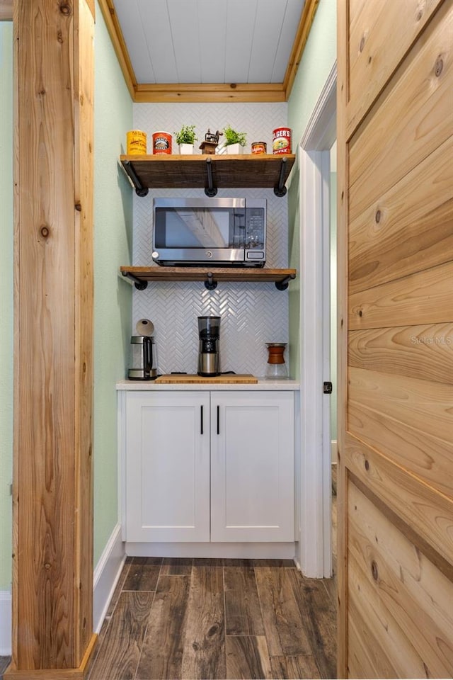 378 W Osceola St, Clermont, FL 34711 - detailed view of stainless steel microwave, wood finished floors, ornamental molding, baseboards, and tasteful backsplash