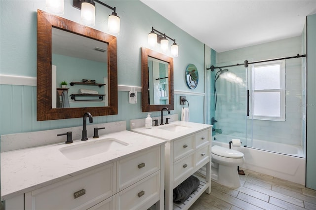 378 W Osceola St, Clermont, FL 34711 - full bathroom with toilet, vanity, combined bath / shower with glass door, a wainscoted wall, and wood finished floors