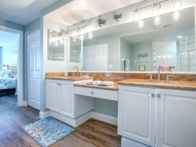 3425 S Atlantic Ave Unit 1101, Daytona Beach, FL 32118 - bathroom featuring wood finished floors, double vanity, and ensuite bath