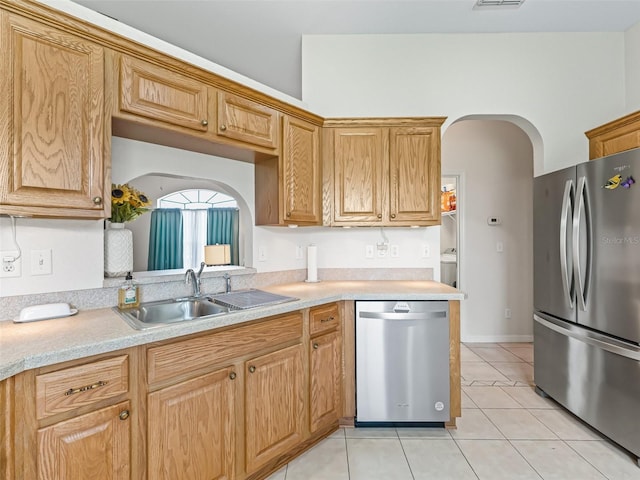 11019 SE 170th Lane Rd, Summerfield, FL 34491 - kitchen featuring appliances with stainless steel finishes, arched walkways, a sink, light tile patterned flooring, and light countertops
