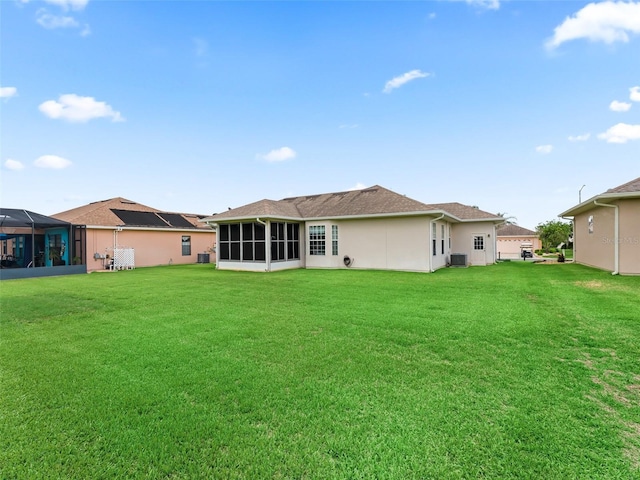 11019 SE 170th Lane Rd, Summerfield, FL 34491 - back of house featuring a sunroom, a lawn, and central AC unit