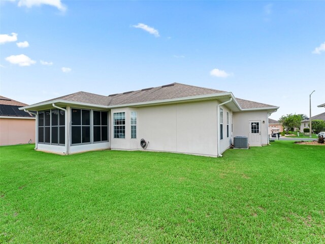11019 SE 170th Lane Rd, Summerfield, FL 34491 - rear view of property featuring a lawn, a sunroom, stucco siding, and roof with shingles