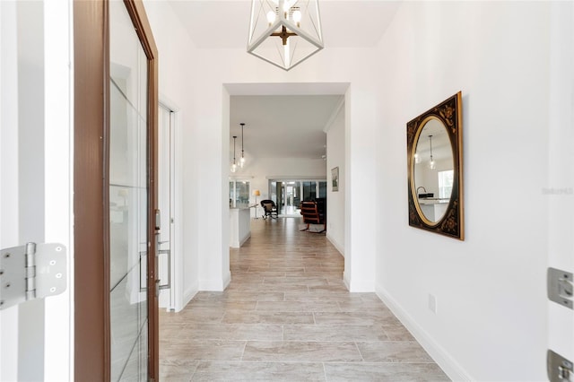 3769 Causey Ct, The Villages, FL 32163 - hall featuring a chandelier and baseboards