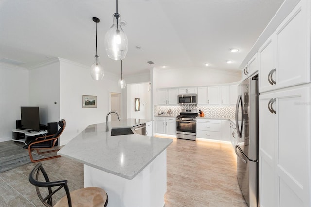 3769 Causey Ct, The Villages, FL 32163 - kitchen with appliances with stainless steel finishes, a sink, lofted ceiling, backsplash, and a large island