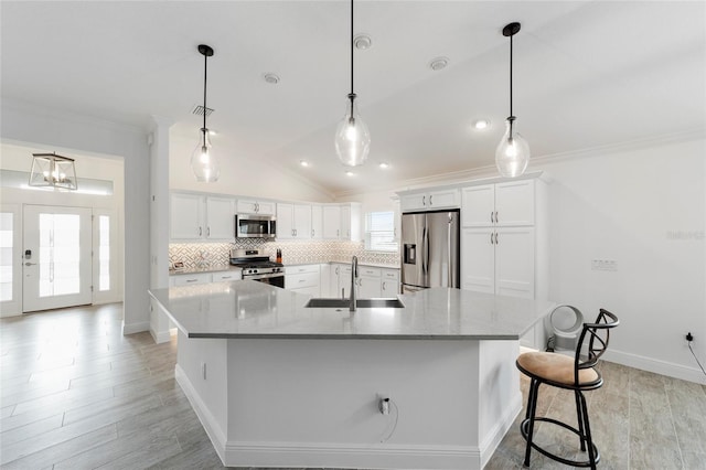 3769 Causey Ct, The Villages, FL 32163 - kitchen featuring appliances with stainless steel finishes, a sink, ornamental molding, white cabinetry, and vaulted ceiling
