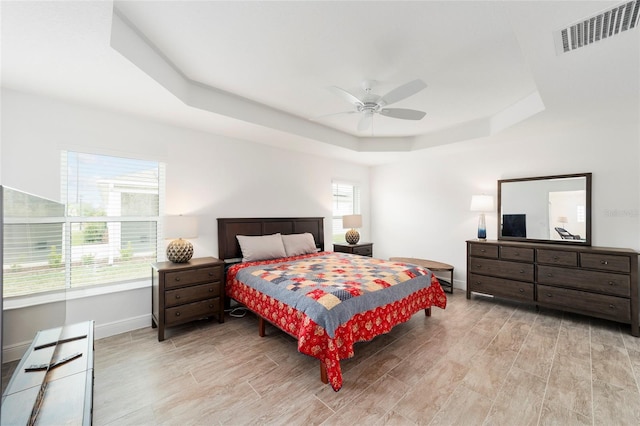 3769 Causey Ct, The Villages, FL 32163 - bedroom featuring a tray ceiling, baseboards, light wood-style flooring, and ceiling fan