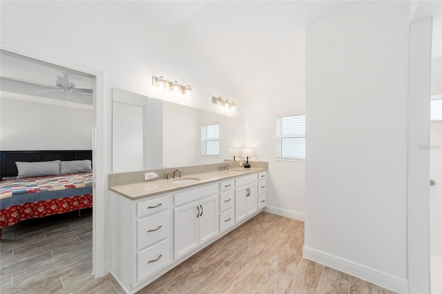 3769 Causey Ct, The Villages, FL 32163 - ensuite bathroom featuring wood tiled floors, double vanity, lofted ceiling, ceiling fan, and baseboards