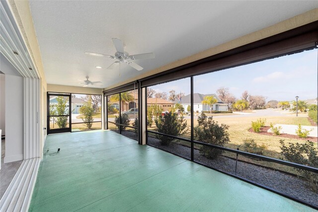 3769 Causey Ct, The Villages, FL 32163 - unfurnished sunroom featuring a ceiling fan and a residential view