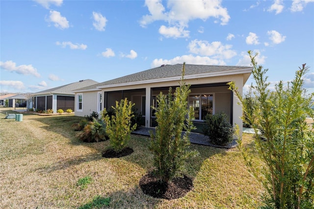 3769 Causey Ct, The Villages, FL 32163 - rear view of house with a sunroom, a lawn, and stucco siding