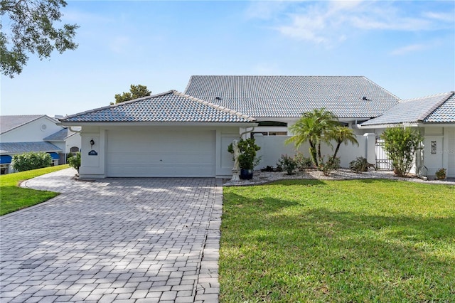 6048 Topsail Rd, Lady Lake, FL 32159 - view of front of house featuring a tiled roof, decorative driveway, an attached garage, and stucco siding
