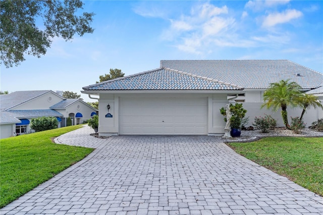 6048 Topsail Rd, Lady Lake, FL 32159 - view of front of property featuring decorative driveway, a front lawn, a garage, a tile roof, and stucco siding