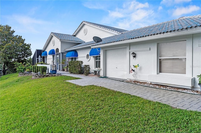 6048 Topsail Rd, Lady Lake, FL 32159 - rear view of property with a lawn, a tiled roof, stucco siding, and an attached garage