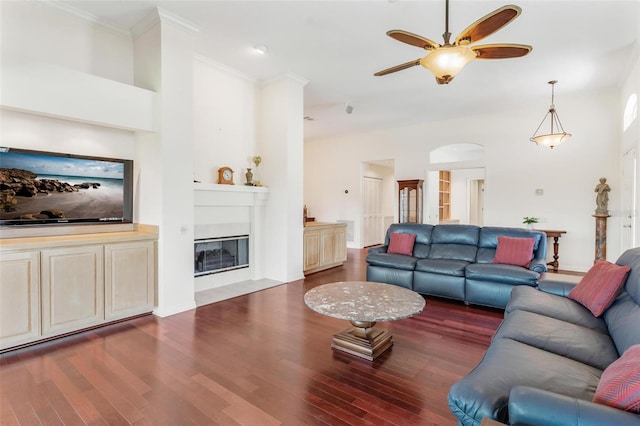 6048 Topsail Rd, Lady Lake, FL 32159 - living area with a ceiling fan, wood finished floors, a fireplace with flush hearth, crown molding, and a towering ceiling