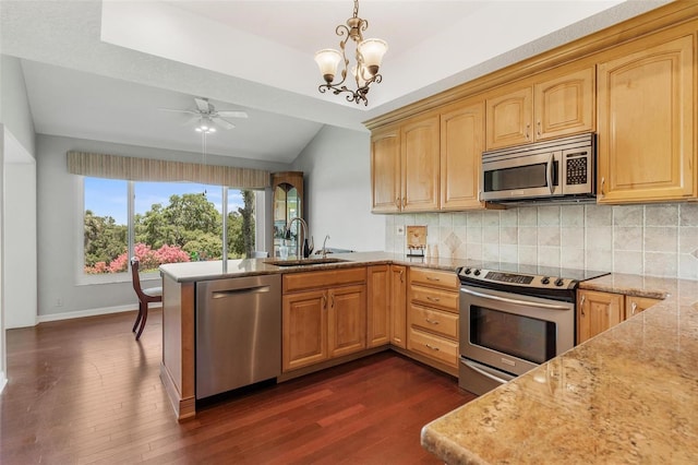 6048 Topsail Rd, Lady Lake, FL 32159 - kitchen featuring stainless steel appliances, a peninsula, dark wood-style floors, light stone countertops, and decorative backsplash