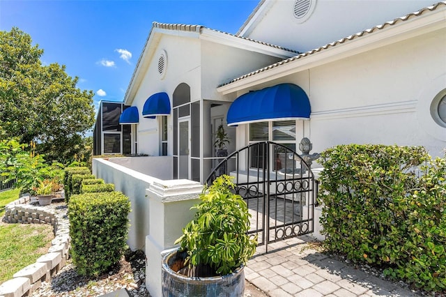 6048 Topsail Rd, Lady Lake, FL 32159 - property entrance with stucco siding and a gate
