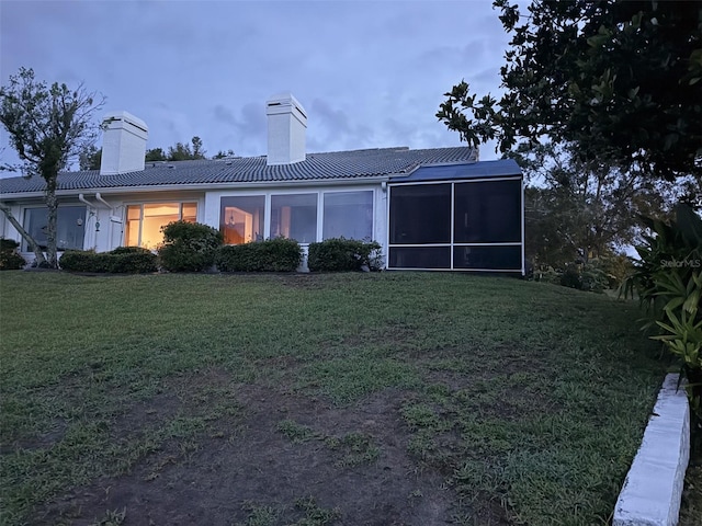 6048 Topsail Rd, Lady Lake, FL 32159 - back of property featuring a chimney, a sunroom, a yard, and a tile roof