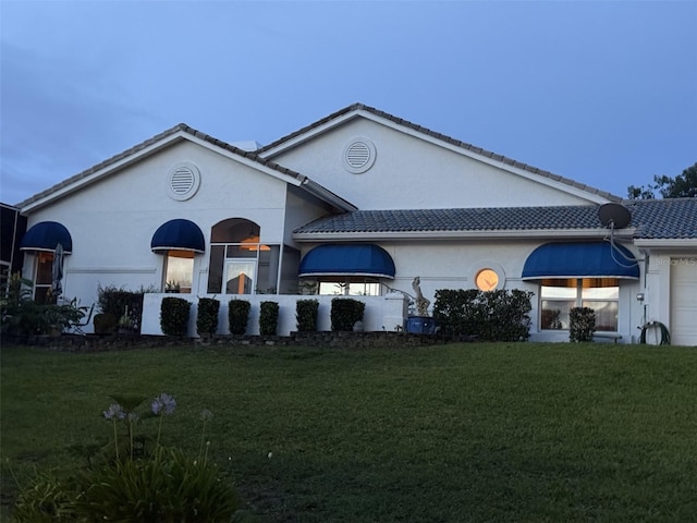 6048 Topsail Rd, Lady Lake, FL 32159 - back of property featuring a yard, an attached garage, and stucco siding