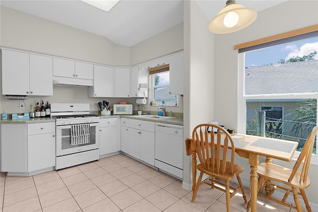 2821 Mediterranean Loop, Tavares, FL 32778 - kitchen with white appliances, under cabinet range hood, a sink, light tile patterned floors, and white cabinetry