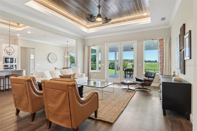 1127 Fiesta Key Cir, Lady Lake, FL 32159 - living room featuring a raised ceiling, dark wood-style flooring, a chandelier, ornamental molding, and wooden ceiling