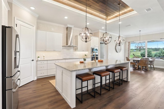 1127 Fiesta Key Cir, Lady Lake, FL 32159 - kitchen with stainless steel fridge, wall chimney exhaust hood, a tray ceiling, dark wood-type flooring, and recessed lighting
