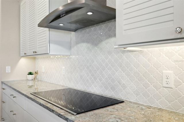 1127 Fiesta Key Cir, Lady Lake, FL 32159 - kitchen featuring wall chimney range hood, black electric stovetop, light stone counters, and tasteful backsplash