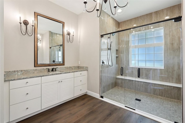1127 Fiesta Key Cir, Lady Lake, FL 32159 - bathroom featuring vanity, a stall shower, wood finished floors, a chandelier, and baseboards