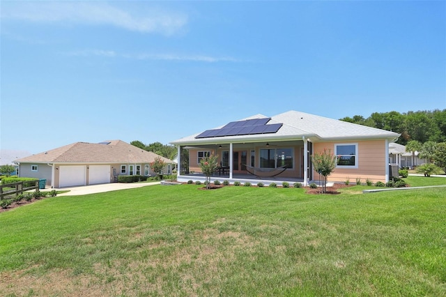 1127 Fiesta Key Cir, Lady Lake, FL 32159 - rear view of property with roof mounted solar panels, ceiling fan, a yard, and driveway