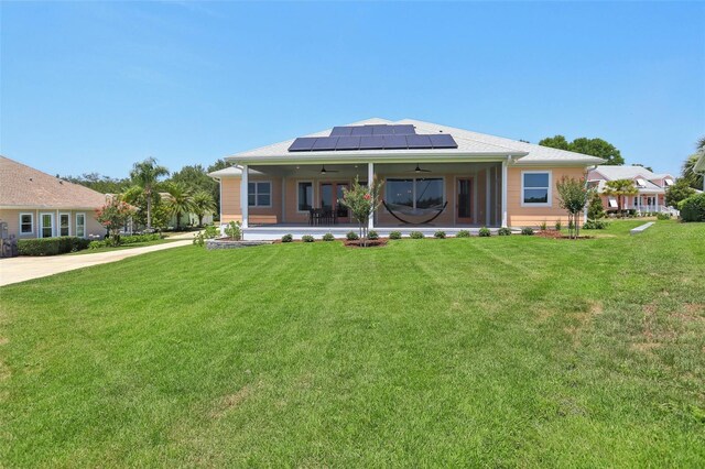 1127 Fiesta Key Cir, Lady Lake, FL 32159 - rear view of property with ceiling fan, roof mounted solar panels, and a yard