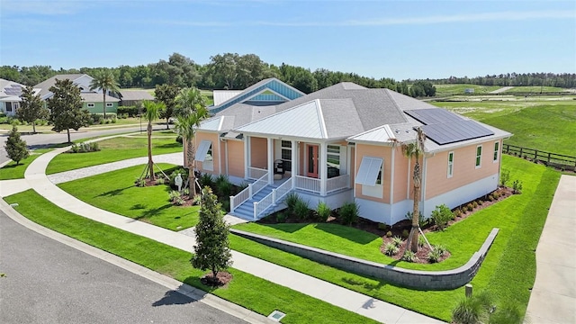 1127 Fiesta Key Cir, Lady Lake, FL 32159 - view of front of home with a porch, solar panels, metal roof, and a standing seam roof