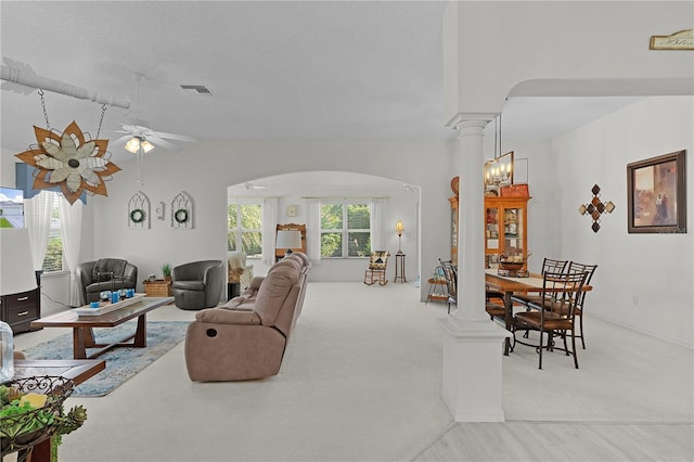 2738 Morven Park Way, The Villages, FL 32162 - living room with arched walkways, light carpet, ceiling fan, ornate columns, and vaulted ceiling