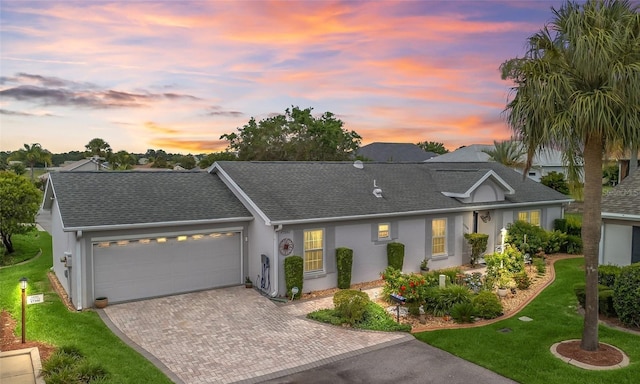 17380 SE 111th Ct, Summerfield, FL 34491 - view of front facade with a garage, a front yard, decorative driveway, stucco siding, and roof with shingles