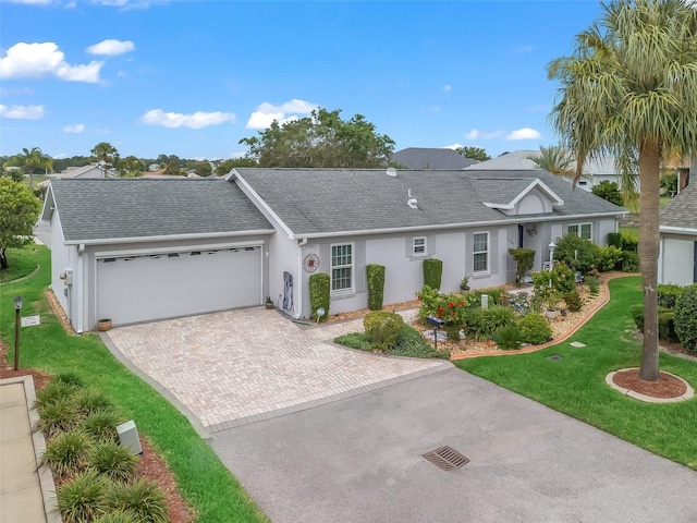 17380 SE 111th Ct, Summerfield, FL 34491 - ranch-style home featuring decorative driveway, a shingled roof, a front lawn, a garage, and stucco siding
