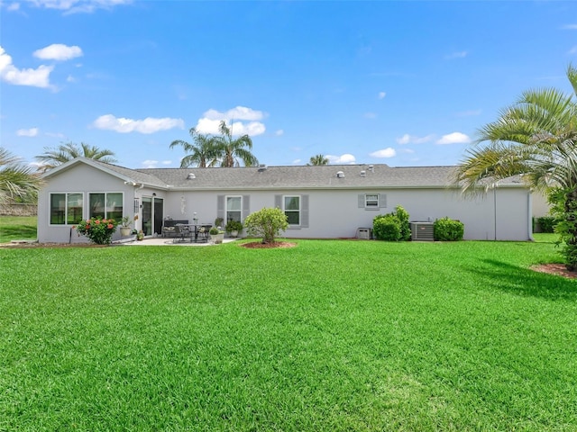 17380 SE 111th Ct, Summerfield, FL 34491 - back of house with a patio, central AC, stucco siding, and a yard