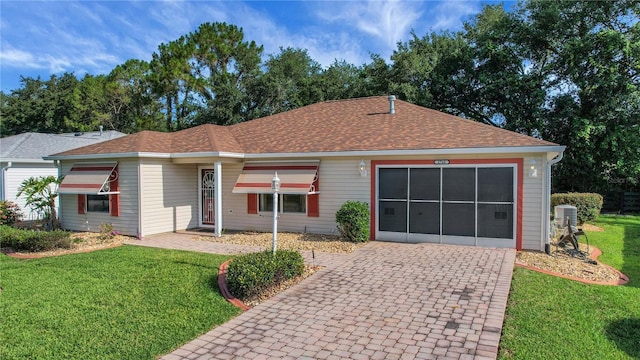2766 Privada Dr, The Villages, FL 32162 - ranch-style house featuring a garage, decorative driveway, a front lawn, and roof with shingles