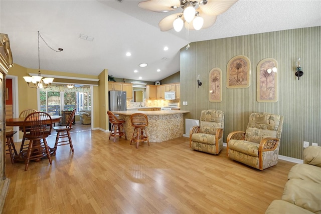 2766 Privada Dr, The Villages, FL 32162 - living area featuring light wood-style flooring, a chandelier, ceiling fan, lofted ceiling, and baseboards