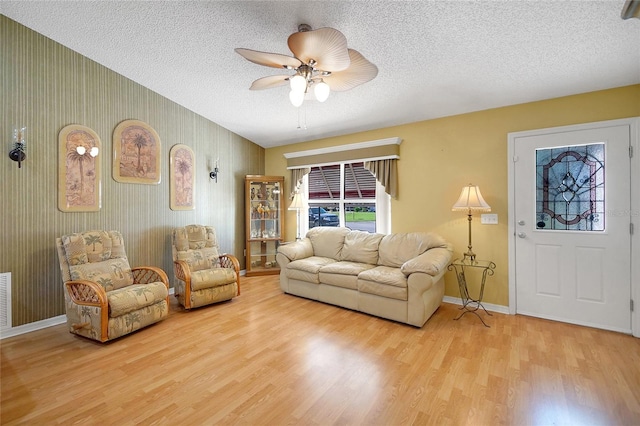 2766 Privada Dr, The Villages, FL 32162 - living area with light wood-style flooring, ceiling fan, baseboards, and a textured ceiling
